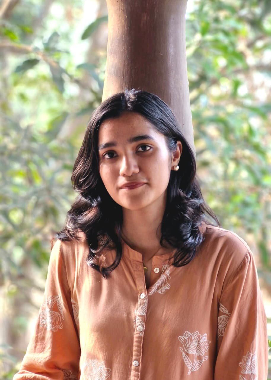 Portrait of Keerthana S V standing outdoors in front of a tree.